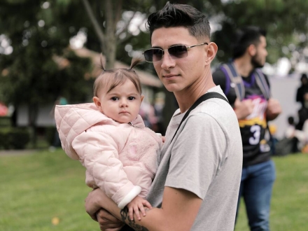 Papá joven con niña en brazos