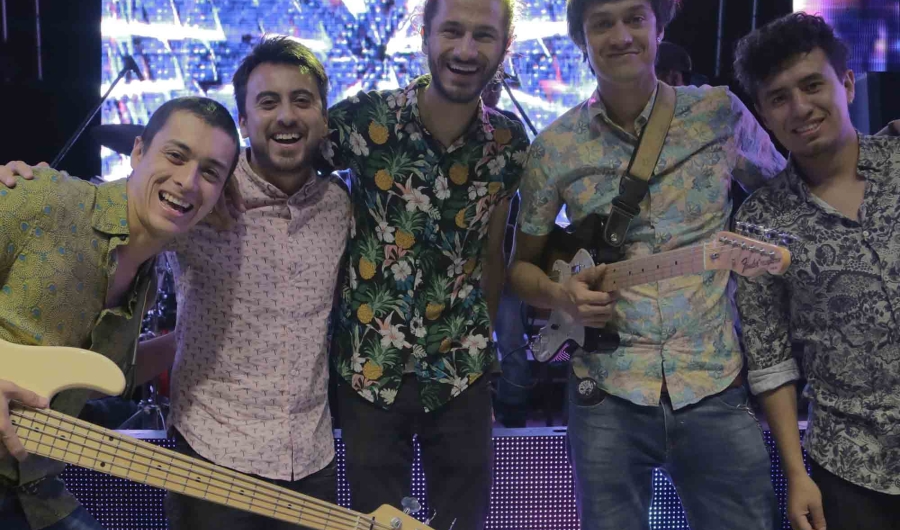Hombres frente a una pantalla posando para la cámara