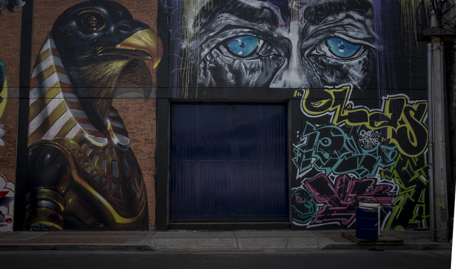Dibujos de águila y ojos azules en una pared de la ciudad