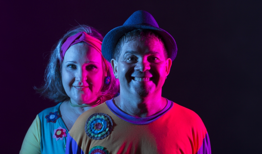 Hombre y mujer en fondo negro con luces de colores