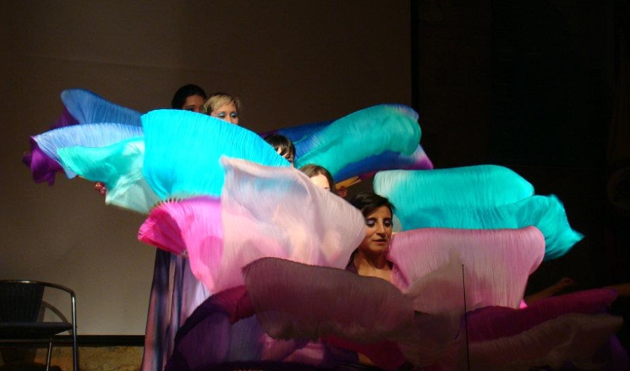 Mujeres danzando con telas de colores