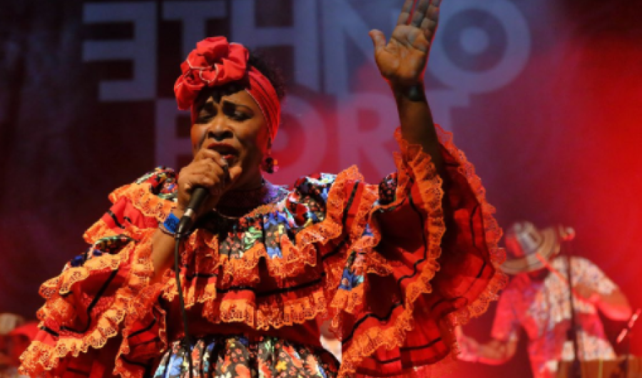 Fotografía de Lina Babilonia cantando con la mano arriba