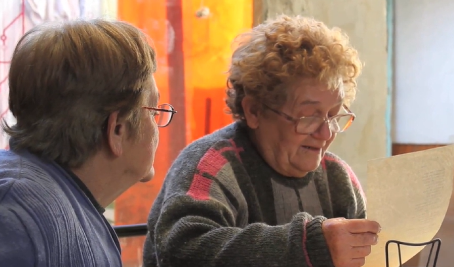 Foto de dos Mujeres con gafas que leen una hoja de papel 