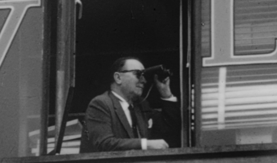 señor mirando con binoculares por la ventana