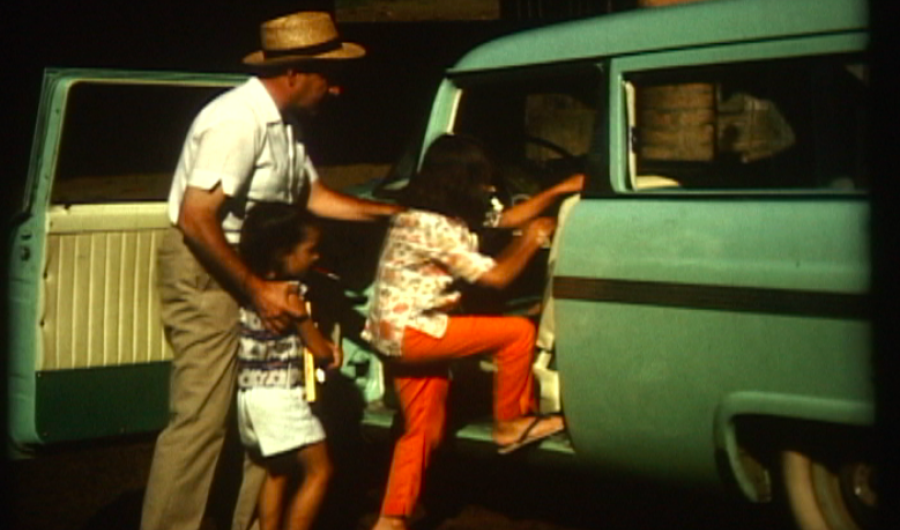 hombre con dos niñas subiendo a un carro