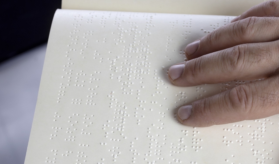 Mano sobre texto en braille.