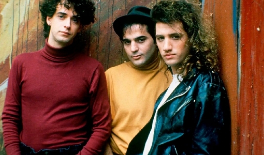 Tres integrantes de Soda Stereo enfrente de una pared.