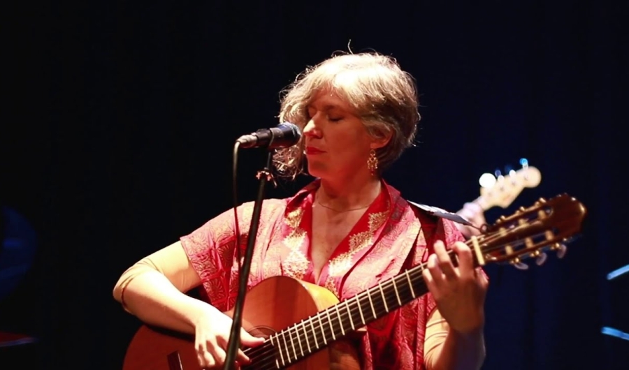 Carolina Guttmann tocando guitarra y cantando.