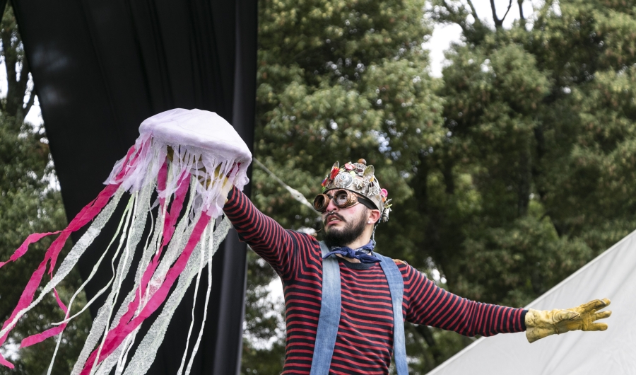 Artista disfrazado que juega con un dispositivo colorido