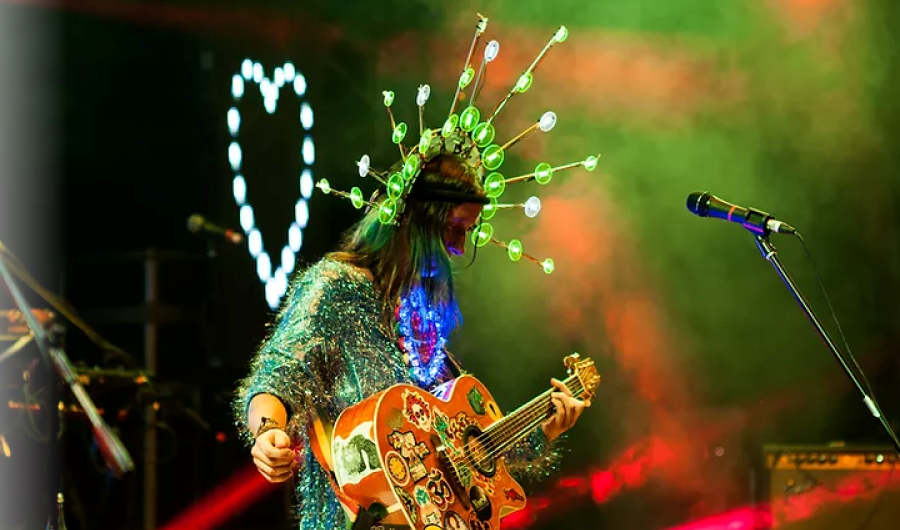 Andrea Echeverri con su guitarra llena de calcomanías en escena 