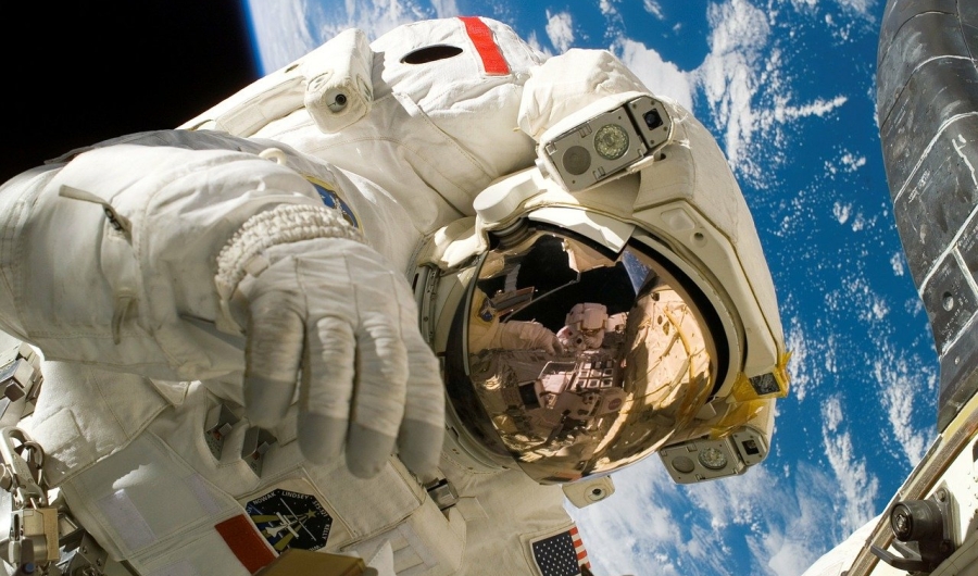 Astronauta en traje espacial con la Tierra de fondo.