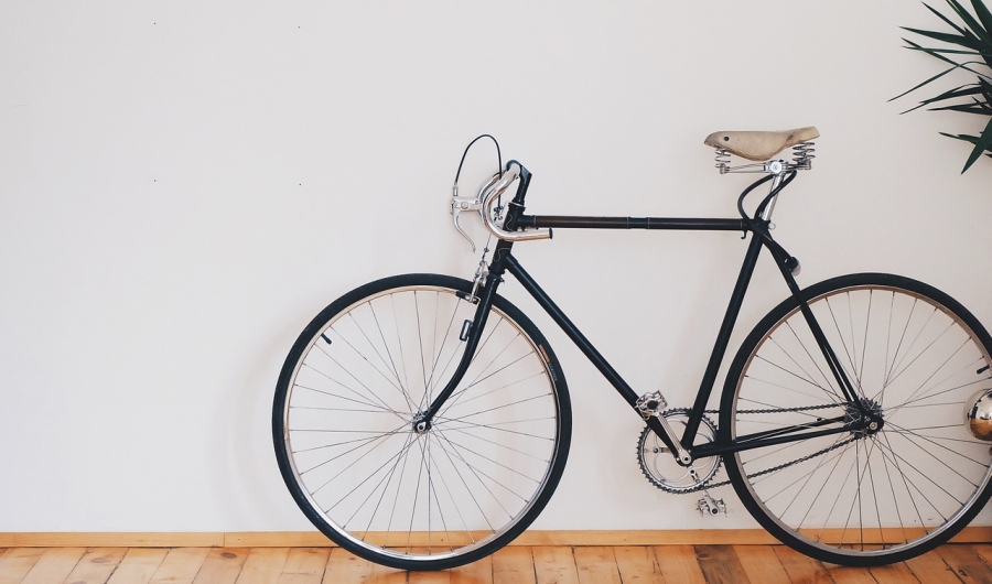 Bicicleta parada enfrente de una pared blanca.