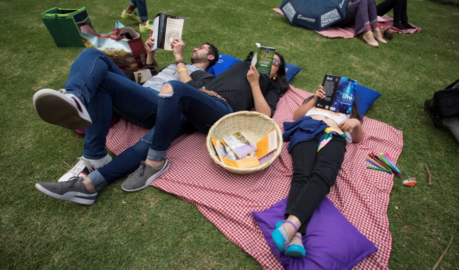Personas leyendo en parque público