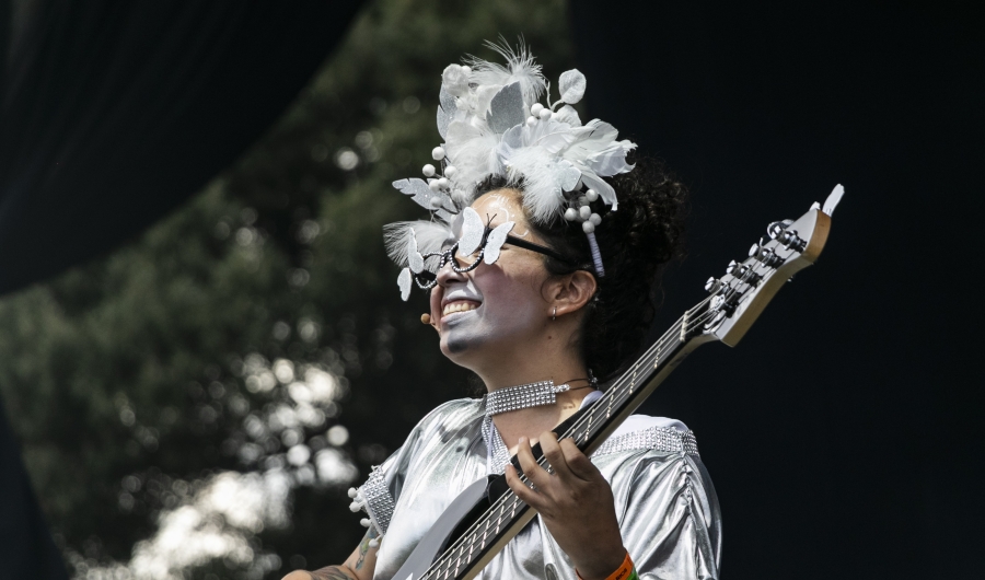 Mujer vestida y maquillada de blanco tocando guitarra