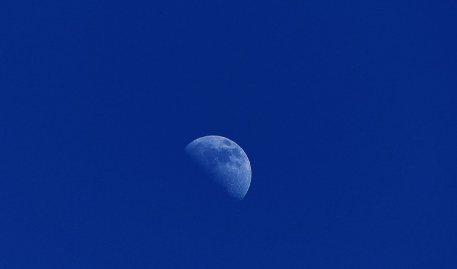 Media luna en cielo azul.
