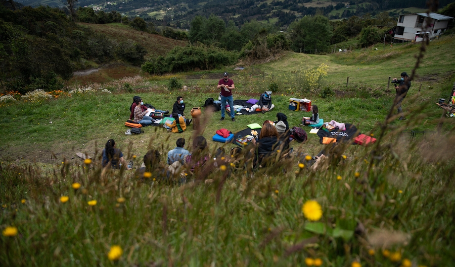 Jóvenes y niños en un campo hablando con mediadior del Planetario.