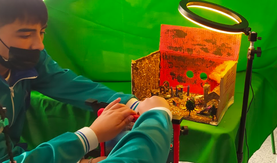 Niños organizando una maqueta con un foco de luz
