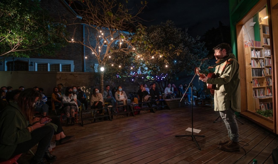 Hombre cantando en una librería en la noche