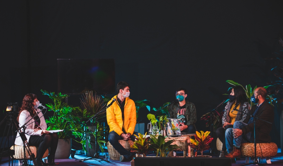 Cuatro personas sobre la tarima de la Sala Gaitán con plantas. 