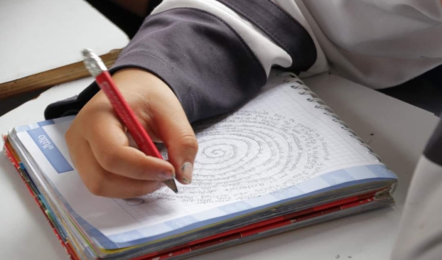 Niño escribiendo y dibujando en una agenda 