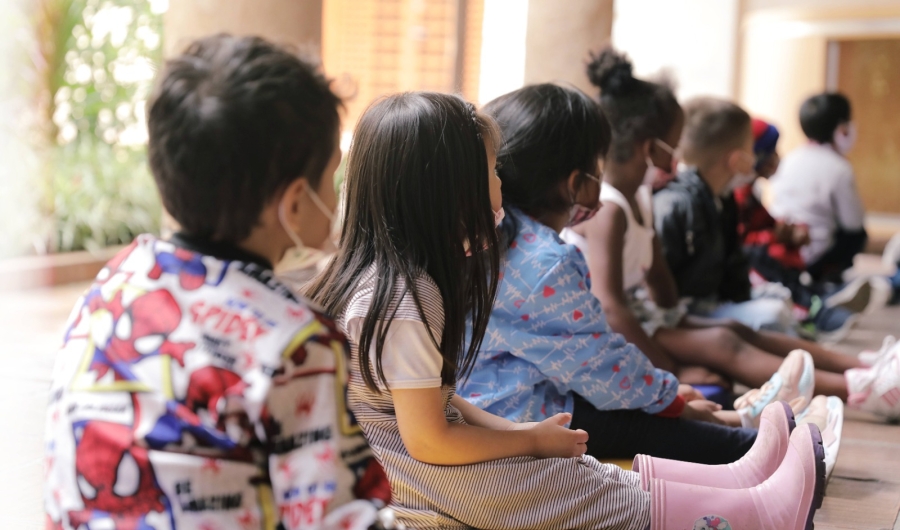 Fila de niños sentados en el piso