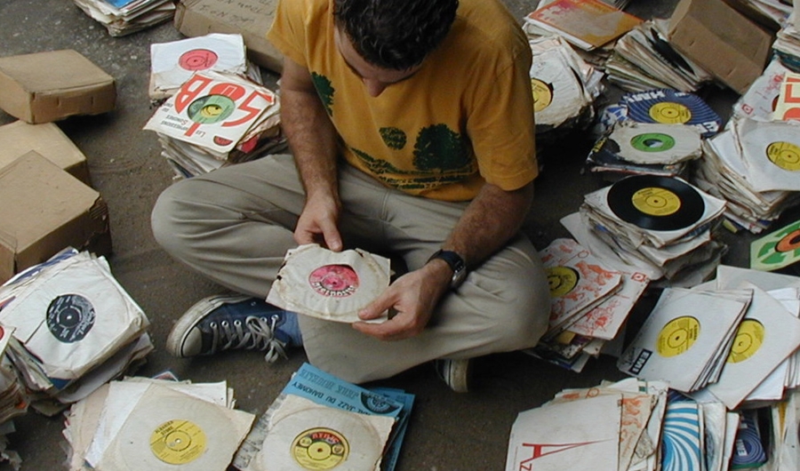 Samy Ben Redjeb - Analog Africa - persona sentada con caratulas de disco