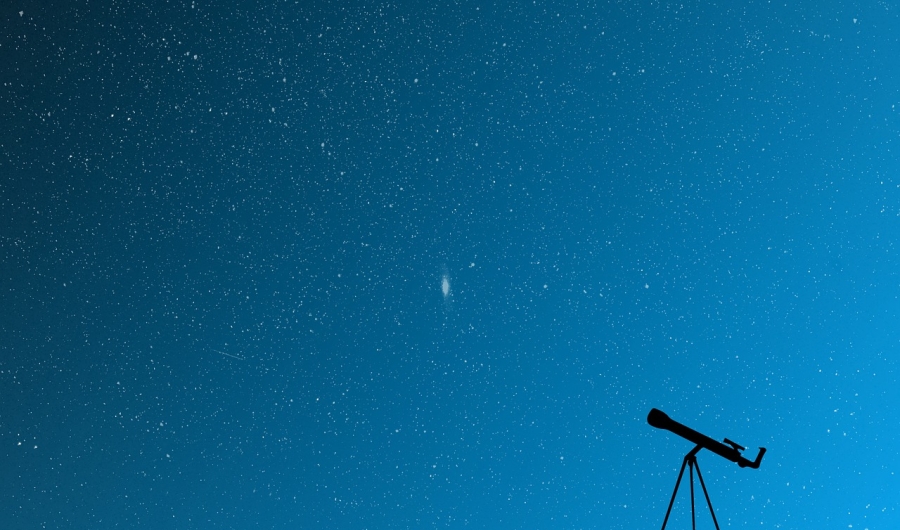 Cielo azul con estrellas y un telescopio en el suelo.