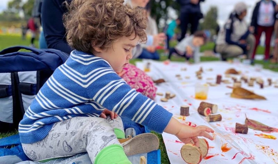 Niña jugando con fichas de madera y pintura en el parque