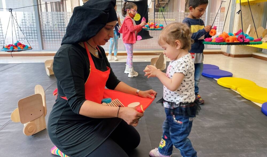 Niñas y niño con artista en laboratorio artístico