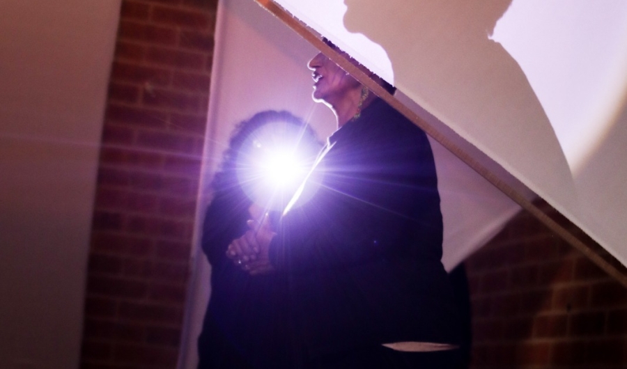 hombre vestido de negro con una luz en sus manos