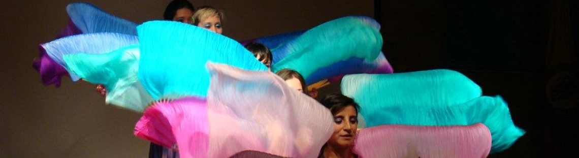 Mujeres danzando con telas de colores