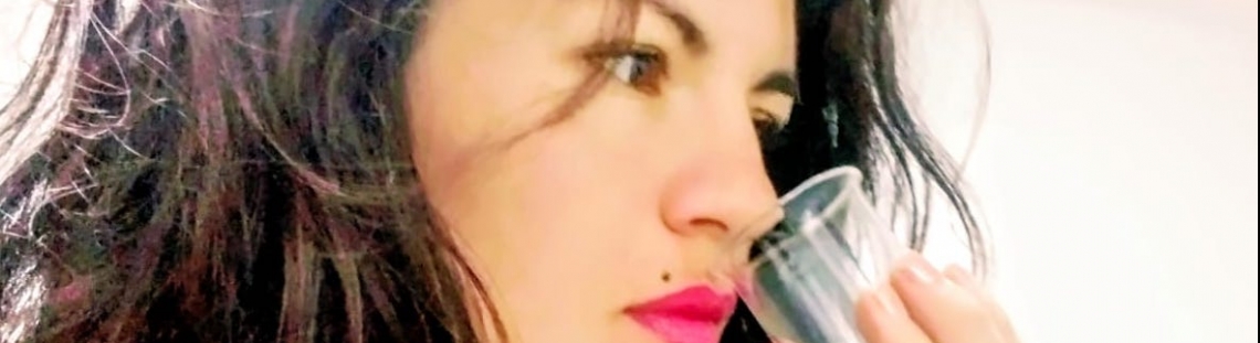Foto de perfil de Angie Rodríguez oliendo una sustancia de un vaso. 