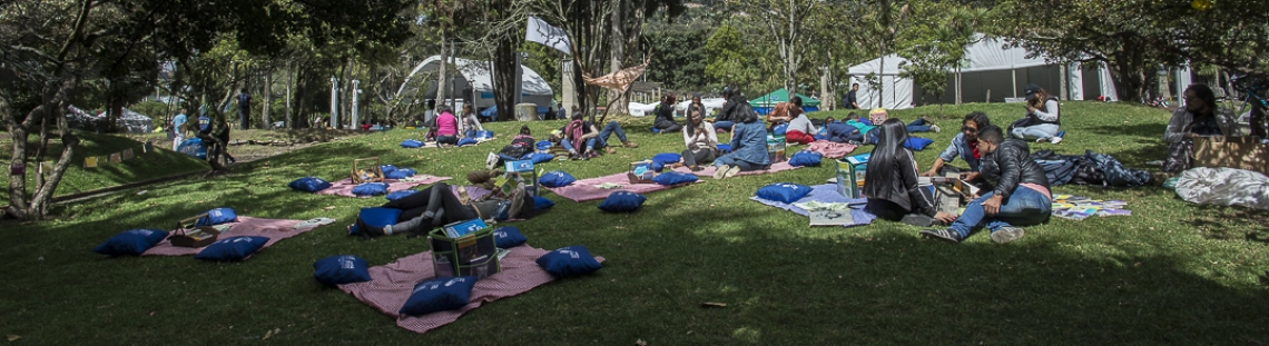 Personas disfrutando de una actividad de lectura al aire libre.