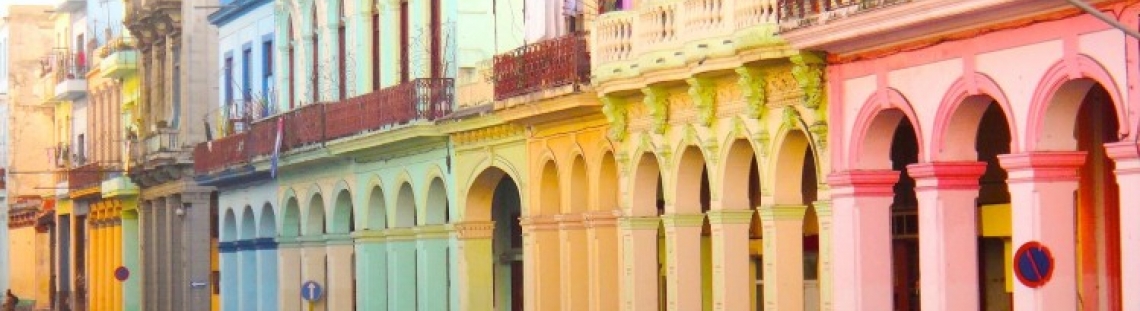 Fotografía de casas caribeás de colores y carro antiguo