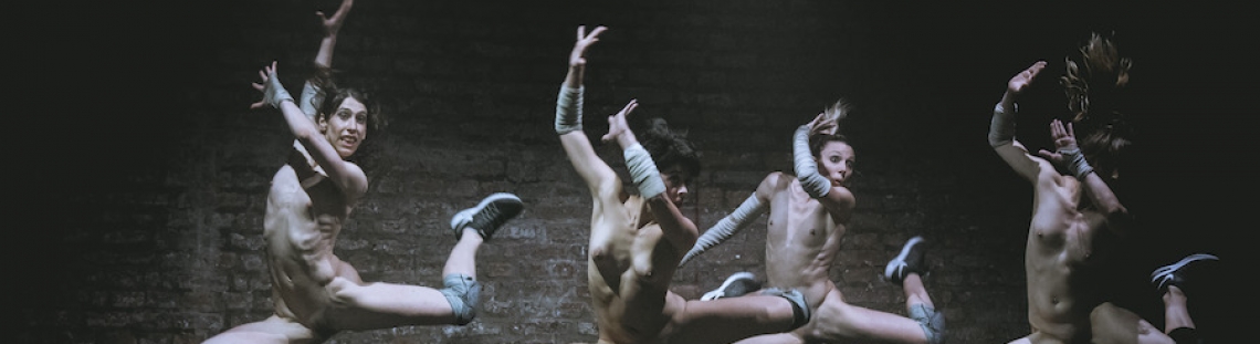Cuatro actores semidesnudos saltando en una presentación artística. 