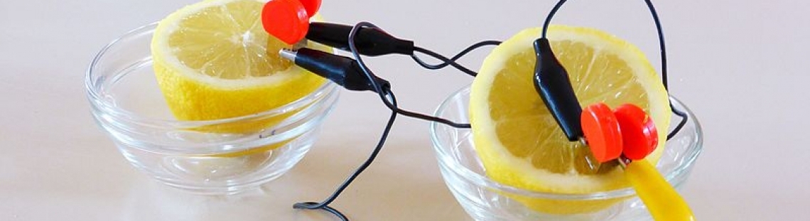 Dos limones con cables dentro de dos recipientes con agua