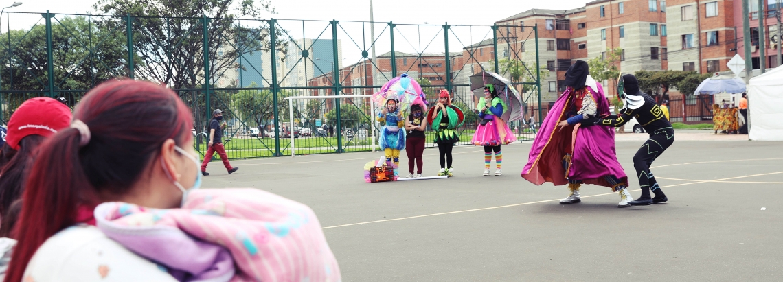 Familias disfrutando de la presentación del Programa Nidos en un parque de Bogotá
