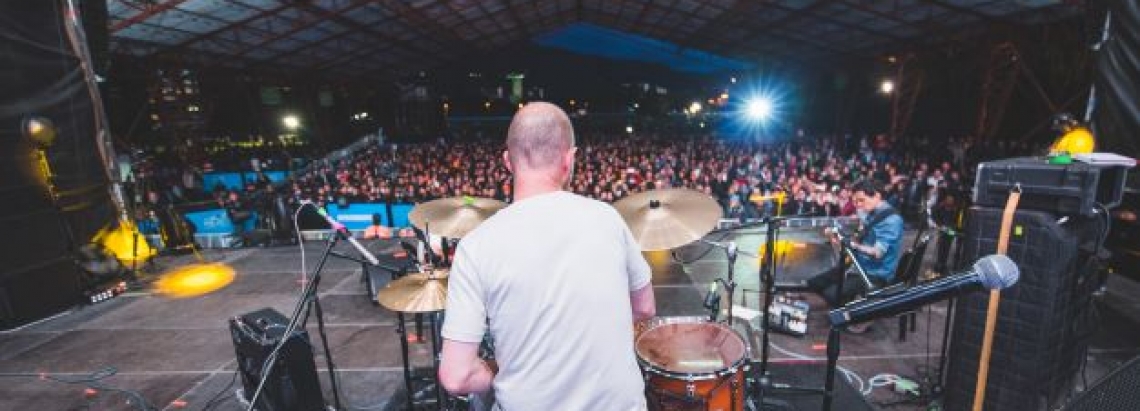 Hombre tocando bateria ante gran público