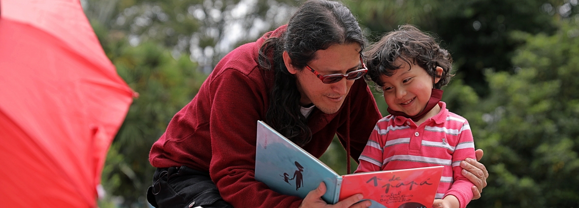 Niño en primera infancia leyendo con su papá