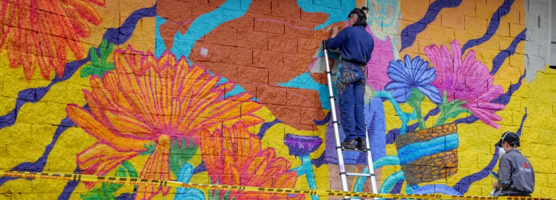 El costado de una zona bajo puente siendo intervenido por un par de artistas