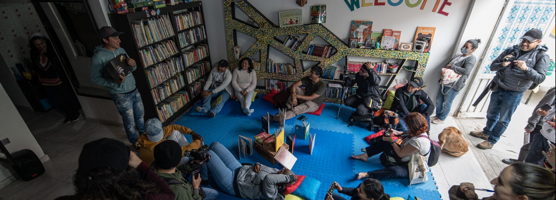 Grupo de personas reunido en una biblioteca de día.