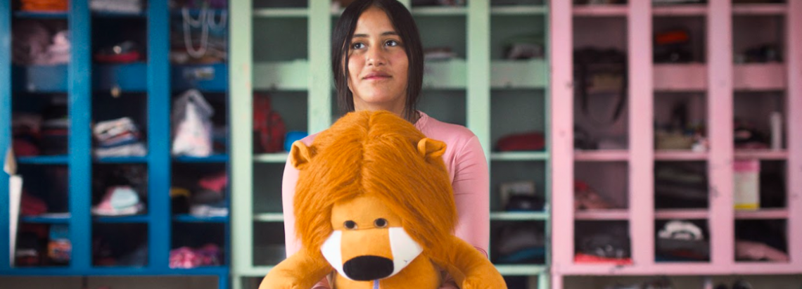 Niña con un peluche de león en la mano 