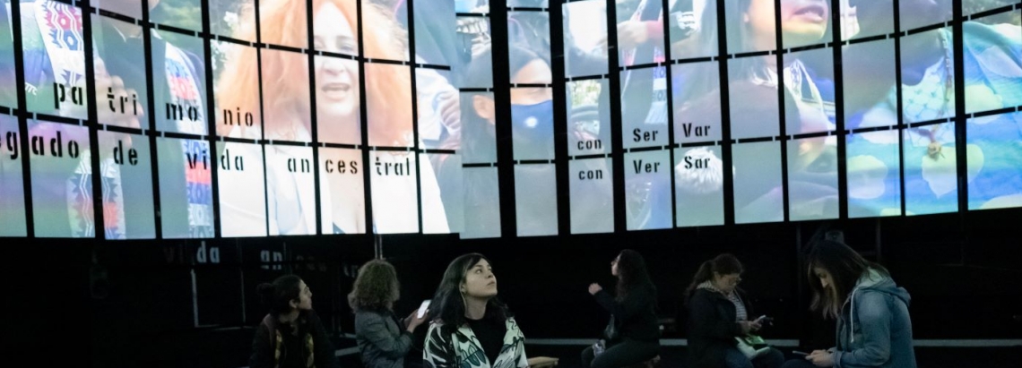 personas sentadas en círculo alrededor de una pantalla