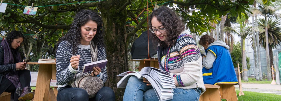 mujeres leyendo bajo los árboles