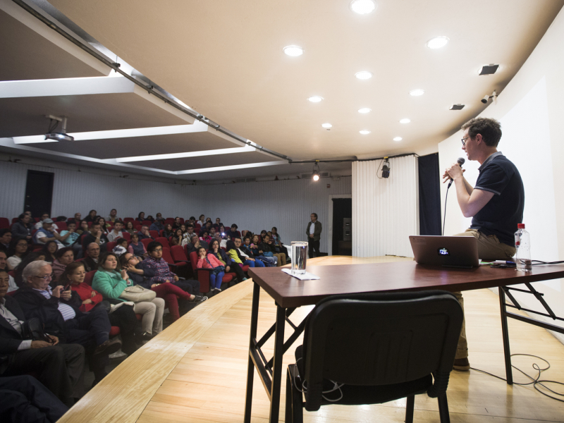 Hombre dando una conferencia en un salón con público