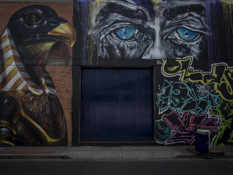 Dibujos de águila y ojos azules en una pared de la ciudad