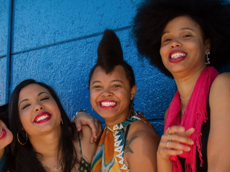 Mujeres sonriendo para la cámara sobre un fondo azul