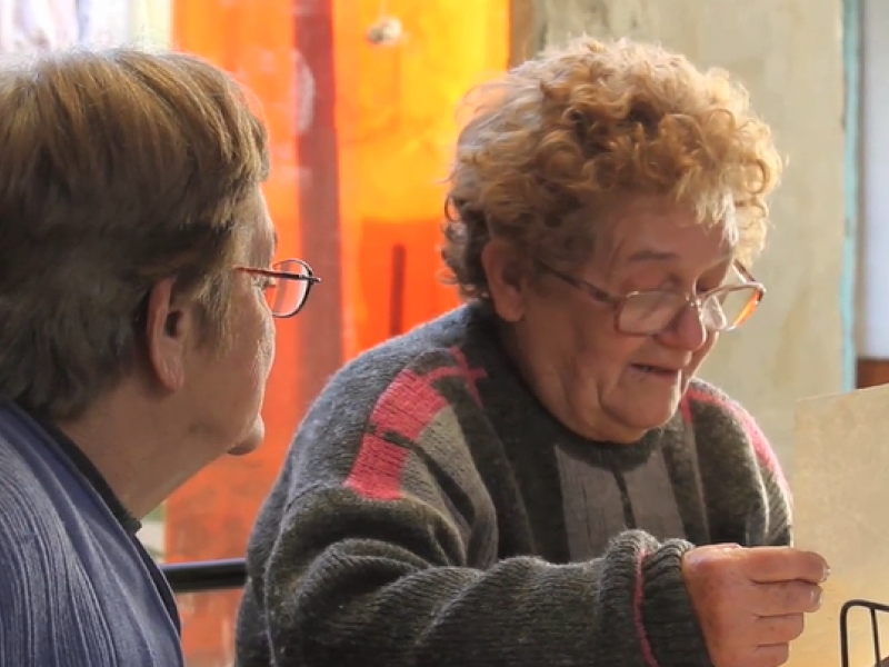 Foto de dos Mujeres con gafas que leen una hoja de papel 