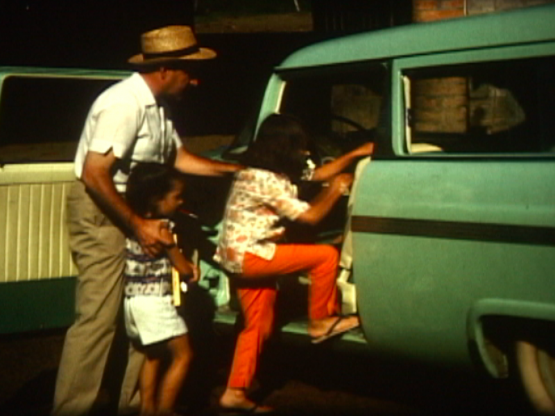 hombre con dos niñas subiendo a un carro