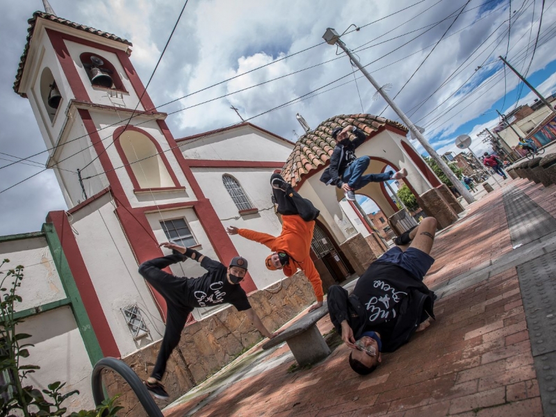 Cuatro jóvenes bailando hip hop frente a una iglesia_Serenata Rap 2020